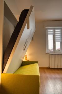 Un dormitorio con una cama amarilla y una escalera en CaseOspitali - CASA DIVA monolocale in centro storico, en Cernusco sul Naviglio