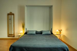una camera con un letto con due lampade e uno specchio di CaseOspitali - CASA DIVA monolocale in centro storico a Cernusco sul Naviglio