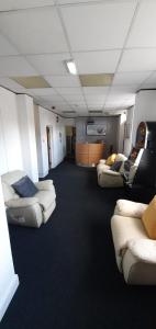 una habitación con sofás y sofás en un edificio en The Lodge Guest Accommodation, en Barrow-in-Furness