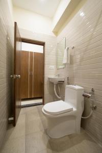 a bathroom with a white toilet and a sink at Hotel Golden Leaves in Hyderabad