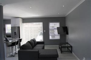sala de estar con sofá y cocina en Milo's Sky Grey Guest House - No Load shedding en Ciudad del Cabo