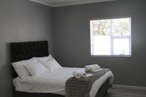 1 dormitorio con 1 cama con 2 toallas en Milo's Sky Grey Guest House - No Load shedding, en Ciudad del Cabo