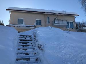 a house with a pile of snow in front of it at Villa Ranta in Rovaniemi