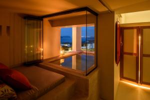 Habitación con ventana y vistas a la piscina. en Potnia Theron Suites, en Akrotiri