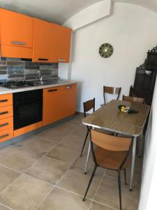 a kitchen with orange cabinets and a table and chairs at Abruzzo Forte e Gentile in Castel di Ieri