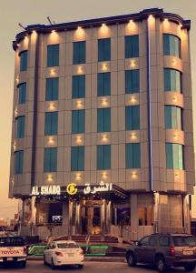 un edificio con coches estacionados frente a él en Al Sharq Hotel, en Hafr Al Batin