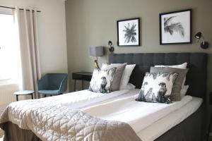 a bedroom with a large bed with two pillows at Hotel Carlshamn in Karlshamn