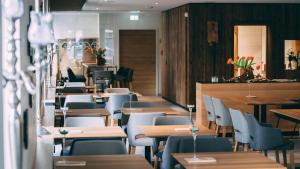 a restaurant with wooden tables and chairs and tables and chairs at Stadthotel Haslach in Haslach im Kinzigtal