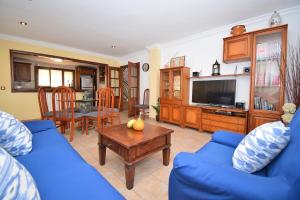 a living room with a blue couch and a table at Villa Cas Barber 226 by Mallorca Charme in Muro