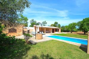 a backyard with a swimming pool and a house at Finca Els Olivers 138 by Mallorca Charme in Alcudia