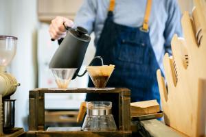 a man in an apron preparing food in a blender at Ryosha Tsukiakari in Yamanakako