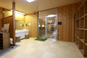 a large bathroom with a shower and a fan at Kiso Mikawaya in Kiso