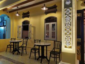 a restaurant with two tables and chairs in a room at Capzule Bed Phuket in Phuket