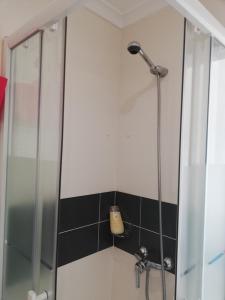 a shower with a glass door in a bathroom at Anthony's Place in Almada
