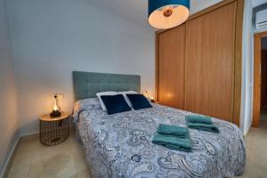 ネルハにあるApartamento Mirador de Nerjaのベッドルーム(青い枕の大型ベッド1台付)