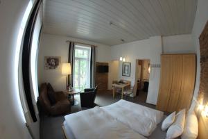 ein Schlafzimmer mit einem Bett und ein Wohnzimmer in der Unterkunft Hotel Almrausch in Bad Reichenhall