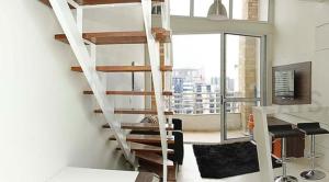 a spiral staircase in a room with a living room at NYC Complex Residence in São Paulo