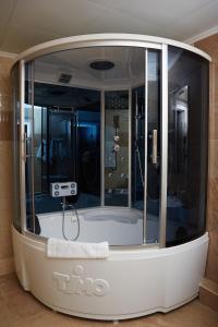 a bathroom with a tub with a shower in it at Gubernskaya Hotel in Kaluga