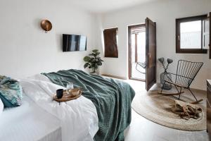 a bed sitting in a bedroom next to a window at Winery Hotel 1870 in Fira
