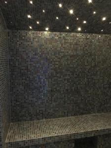 a bathroom with a brown tiled wall with lights at Hôtel La Villa Port d'Antibes & Spa in Antibes