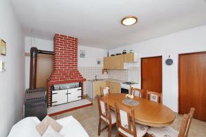 a kitchen and dining room with a table and a fireplace at House Old Fisherman in Tkon