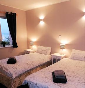 Youghal في يوغال: سريرين في غرفة بها مصباحين ونافذة
