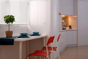 una cocina con sillas rojas y una mesa con una planta en 118 Residences by Travovo, en George Town