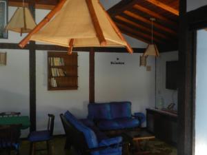 a living room with blue chairs and a couch at Pousada Tempo Rei in Boicucanga