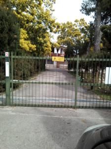 a green fence with a sign on top of it at Edvige'S House in San Felice Circeo