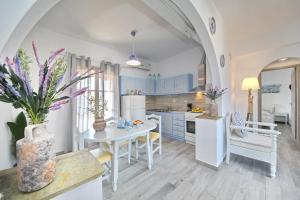 una cocina con armarios azules y una mesa blanca en Yianna Sunny Studios, en Skopelos Town