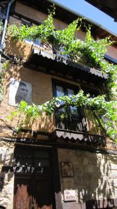 a building with a balcony with plants on it at Casa de la Parra in Mogarraz