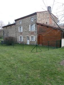 un grande edificio in mattoni con un grande prato davanti di chantacalme a Montboissier