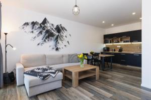 a living room with a couch and a table at Apartmán Háje - V srdci Tatier in Starý Smokovec