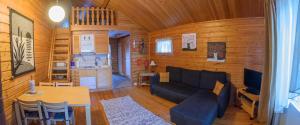 a living room with a couch and a table at Holiday Village Kuukiuru in Vuostimo
