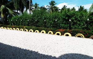 een park met een heg met bloemen en een heg bij Cabanas Recreaciones in Coveñas