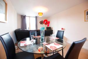 comedor con mesa de cristal y sillas negras en Coventry Home, en Coventry