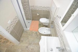 La salle de bains est pourvue de toilettes et d'un lavabo. dans l'établissement Residence L'Ulivo, à Budoni