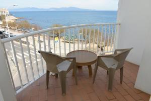 a balcony with a table and chairs and the ocean at Rallye Hotel in L'Escala