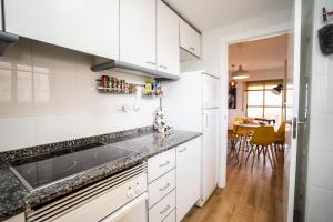 a kitchen with white cabinets and a dining room at El aparta de Ampa in Playa de Gandia