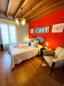1 dormitorio con paredes rojas, 1 cama y 1 sofá en Casa Rural Del Valle Obeso en Pimiango