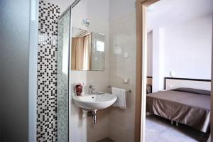 a bathroom with a sink and a bedroom with a bed at Hotel Aquarius in Cattolica