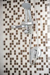 a shower in a bathroom with a tiled wall at Hotel Aquarius in Cattolica