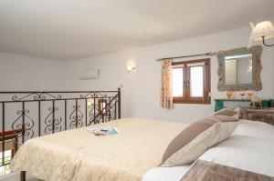 ein weißes Schlafzimmer mit einem Bett und einem Spiegel in der Unterkunft Mateus 2 in Plaka