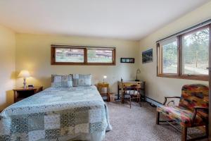 sypialnia z łóżkiem, krzesłem i oknami w obiekcie Great Outdoors - Permit #3428 w mieście Estes Park