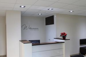 an office with a reception desk with a vase of flowers at Troll's Brauhaushotel in Medebach