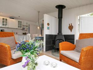 ブロックフスにあるTwo-Bedroom Holiday home in Blokhus 6のリビングルーム(暖炉、花のテーブル付)