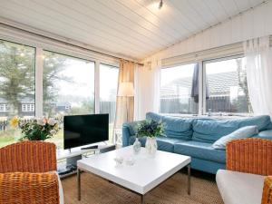 ブロックフスにあるTwo-Bedroom Holiday home in Blokhus 6のリビングルーム(青いソファ、テレビ付)