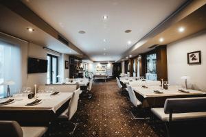 a dining room with white tables and white chairs at Hotel Villa Ekaterina in Vakarel