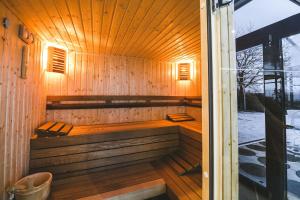 a sauna with a bench in a wooden building at Hotel Villa Ekaterina in Vakarel