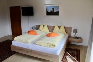 ポスタルにあるGruberhofのベッドルーム1室(オレンジ色の枕が備わるベッド2台付)